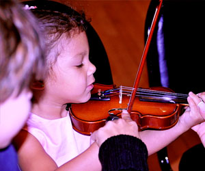 Photo of a child learning to play the violin by the Knight Foundation