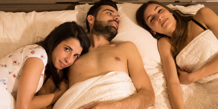 two-women-in-bed-with-man-750x375.jpg